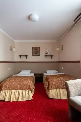 two beds in a room with a red carpet at Pensjonat Stańczyk in Kraków