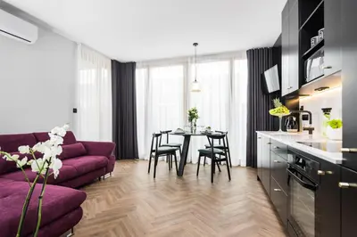 a living room with a purple couch and a table at Moss Apartment in Kraków
