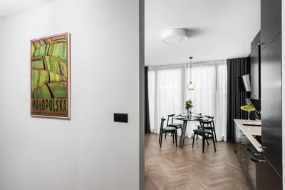 a kitchen and dining room with a table and chairs at Moss Apartment in Kraków