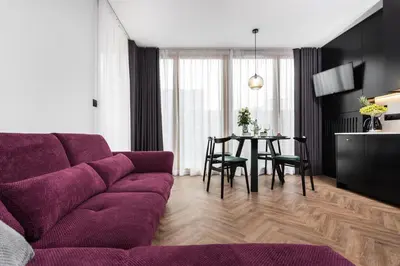 a living room with a purple couch and a table at Moss Apartment in Kraków