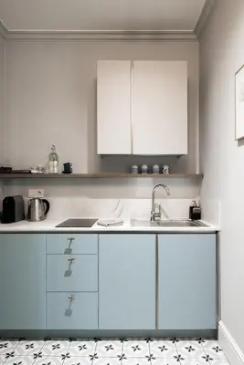 a bedroom with a bed and two chairs and windows at Moja apartments in Kraków