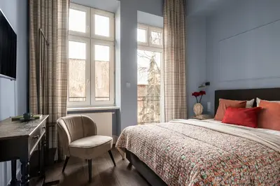 a living room with a chair and a tv at Moja apartments in Kraków