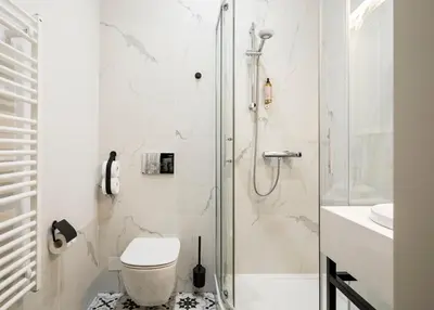 a white bedroom with a white bed with pillows at Moja apartments in Kraków