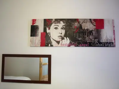 a mirror and a painting on a wall next to at Cracow Old Town Guest House in Kraków