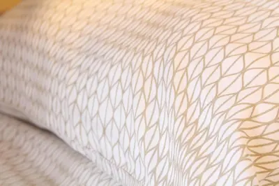 a close up of a white pillow with a brown pattern at Cracow Old Town Guest House in Kraków
