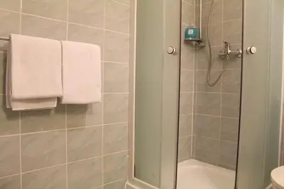 a bathroom with a shower with white towels at Cracow Old Town Guest House in Kraków