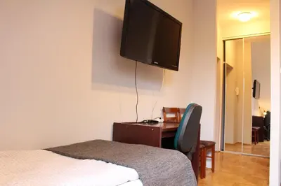 a bedroom with a bed and a television on the wall at Cracow Old Town Guest House in Kraków