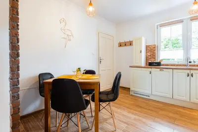 a kitchen and dining room with a table and chairs at Lu Apartments in Oświęcim