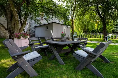 a picnic table and chairs in the grass at Lu Apartments in Oświęcim