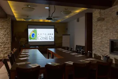 a conference room with a large table and a screen at Hotel Górski Raj in Koninki