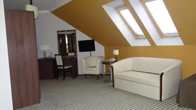 a living room with a white couch and a chair at Hotel Górski Raj in Koninki