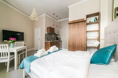 a bedroom with a bed and a table and a television at Apartamenty Wrona | Wrona Apartments in Kraków