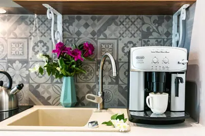 a coffee maker sitting on a counter next to a sink at Apartamenty Wrona | Wrona Apartments in Kraków