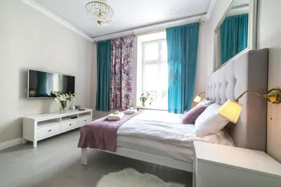 a bedroom with a large bed and a window at Apartamenty Wrona | Wrona Apartments in Kraków