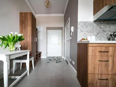 a kitchen with a table and a desk and a hallway at Apartamenty Wrona | Wrona Apartments in Kraków