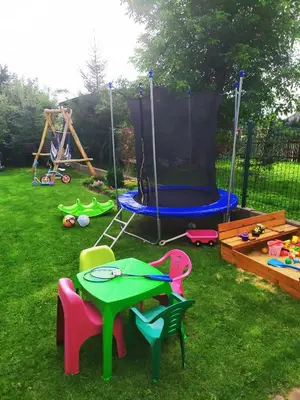 a playground with a table and chairs and a trampoline at Pokoje i Apartamenty na Szkolnej in Zator