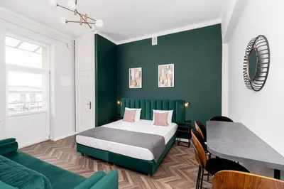 a bedroom with a bed and a green wall at Wawel Boutique Residence - Krakow Old Town in Kraków