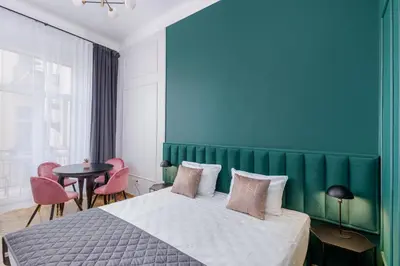 a bedroom with a large bed with a green headboard at Wawel Boutique Residence - Krakow Old Town in Kraków