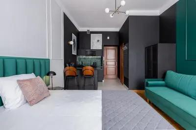 a bedroom with a bed and a couch and a kitchen at Wawel Boutique Residence - Krakow Old Town in Kraków
