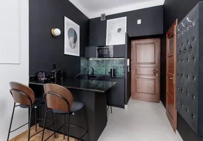 a kitchen with black walls and a bar with stools at Wawel Boutique Residence - Krakow Old Town in Kraków
