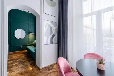 a living room with a table and pink chairs at Wawel Boutique Residence - Krakow Old Town in Kraków