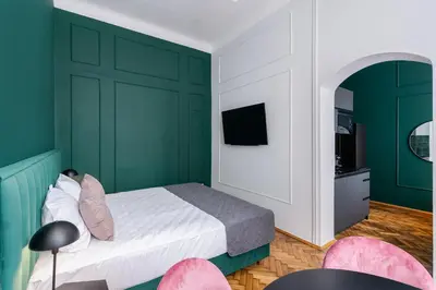 a bedroom with green walls and a bed with pink chairs at Wawel Boutique Residence - Krakow Old Town in Kraków
