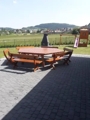 a picnic table and two benches sitting on a brick at Holiday home Limanowa in Limanowa