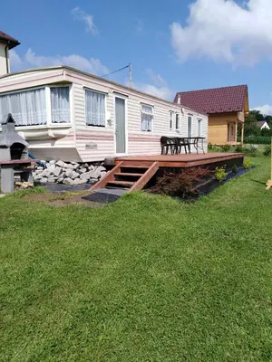 a house with a deck with a dog sitting on it at Leśny Zakątek Radocza in Radocza
