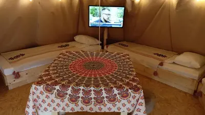a room with two beds and a tv in a tent at Leśny Zakątek Radocza in Radocza
