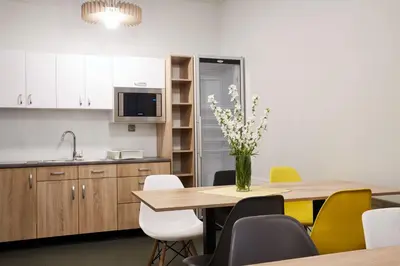 a kitchen with a table with a vase of flowers on it at Polin House in Oświęcim