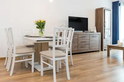a living room with a table and chairs and a tv at Wawrzyńca Apartment with parking in Kraków