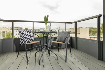 a table and two chairs on a balcony at Wawrzyńca Apartment with parking in Kraków