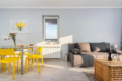 a living room with a couch and a table and yellow chairs at Apartamenty Niko in Zator