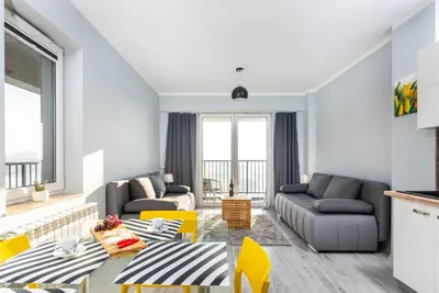 a living room with a table and yellow chairs at Apartamenty Niko in Zator