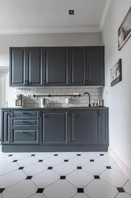 a kitchen with black cabinets and a tiled floor at STAYPOLSKA in Oświęcim