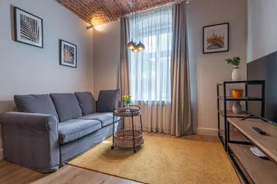 a living room with a blue couch and a window at STAYPOLSKA in Oświęcim