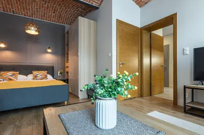 a bedroom with a bed and a vase with flowers at STAYPOLSKA in Oświęcim