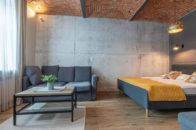 a bedroom with a bed and a couch and a table at STAYPOLSKA in Oświęcim