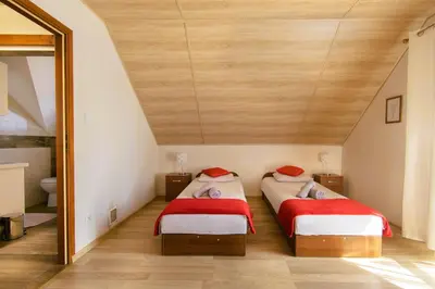 two beds in a room with a wooden ceiling at Bulwary Mszańskie - Domki Całoroczne in Mszana Dolna