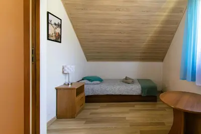 a bedroom with a bed and a wooden ceiling at Bulwary Mszańskie - Domki Całoroczne in Mszana Dolna