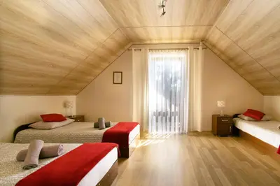 a bedroom with two beds and a large window at Bulwary Mszańskie - Domki Całoroczne in Mszana Dolna