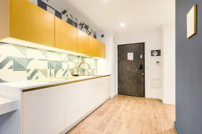a kitchen with white cabinets and a black door at Apartment Old Town Halicka street by NEARTO in Kraków