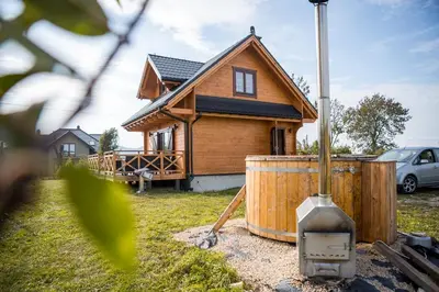 a wooden house with a tank in front of it at Na Dworosku in Golczowice