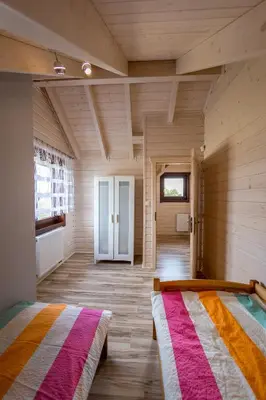 two beds in a room with wooden walls at Na Dworosku in Golczowice