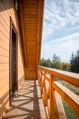 a wooden balcony with a door on a building at Na Dworosku in Golczowice