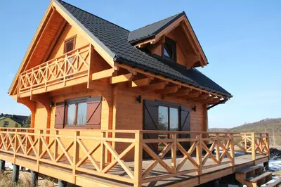 a log cabin with a black roof at Na Dworosku in Golczowice