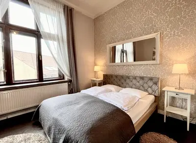 a bedroom with a bed and a mirror on the wall at Apartamenty Długa 27 in Kraków