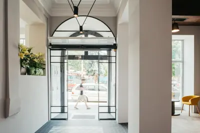 a hallway with a glass door and a person walking down a street at Avena Boutique Hotel by Artery Hotels in Kraków
