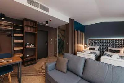 a living room with a couch and a bed at Avena Boutique Hotel by Artery Hotels in Kraków