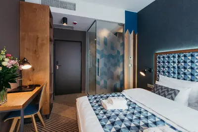 a hotel room with a bed and a desk at Avena Boutique Hotel by Artery Hotels in Kraków